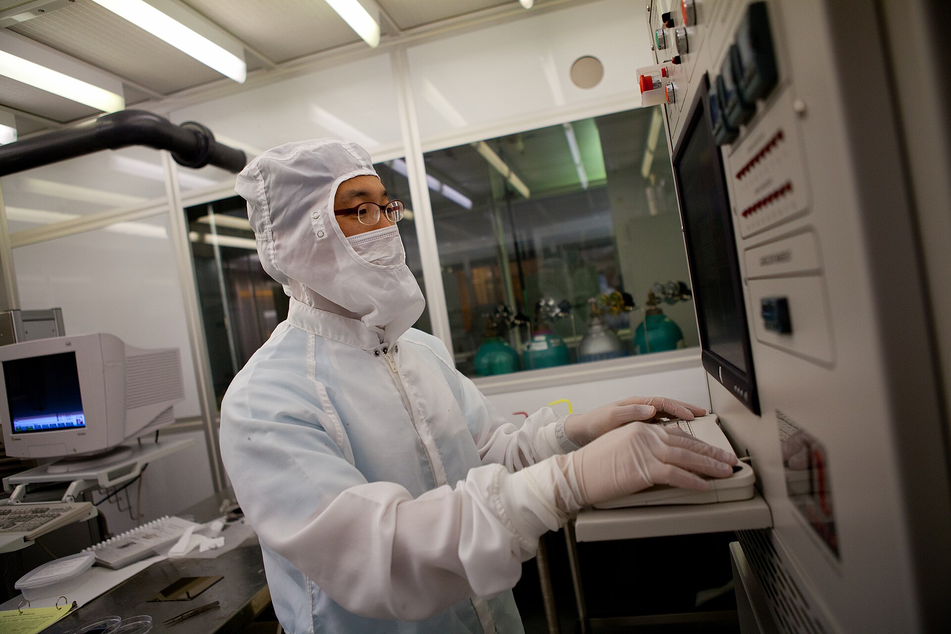researcher inspecting a sample inside a semiconductor cleanroom, related to on-device AI memory chip fabrication research