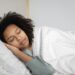 REM sleep 렘수면 — woman sleeping peacefully in bed at night